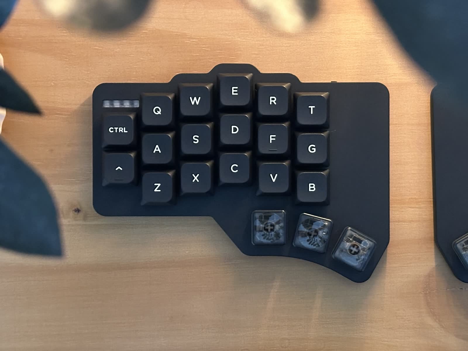 The finished Wolf keyboard on a dark desk beside a trackpad