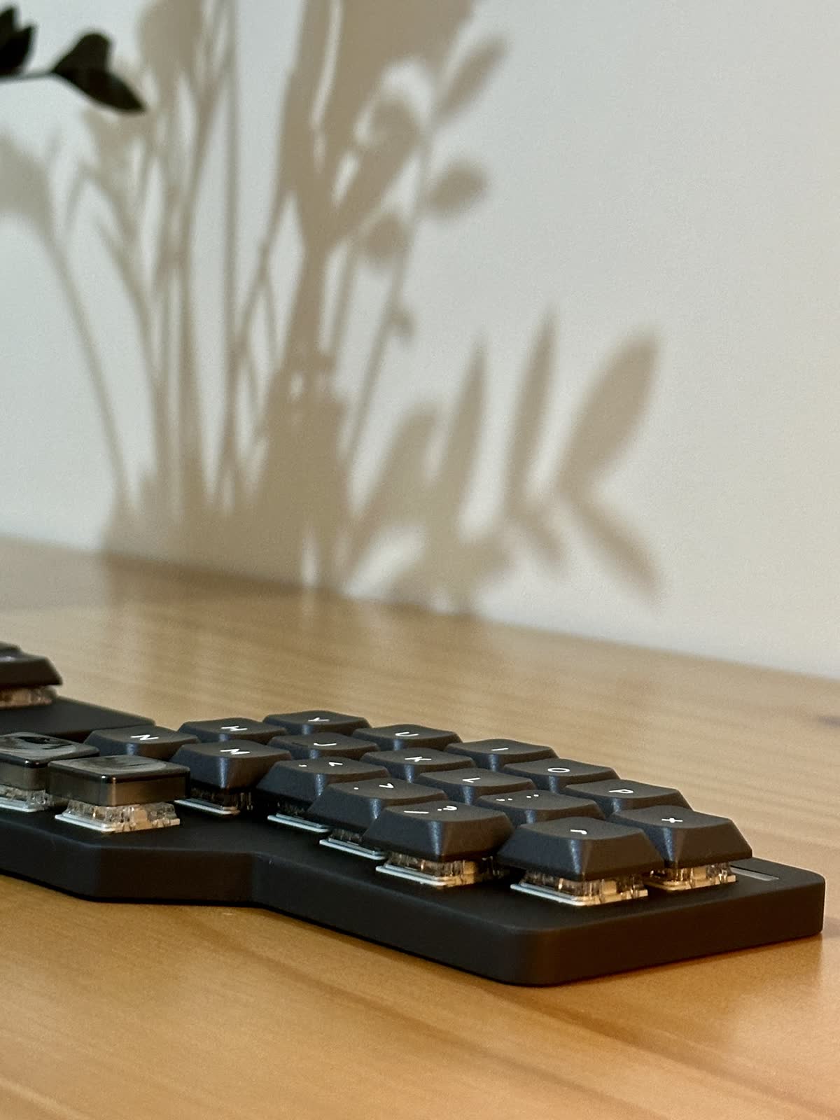 The slim keyboard case seen beside a laptop