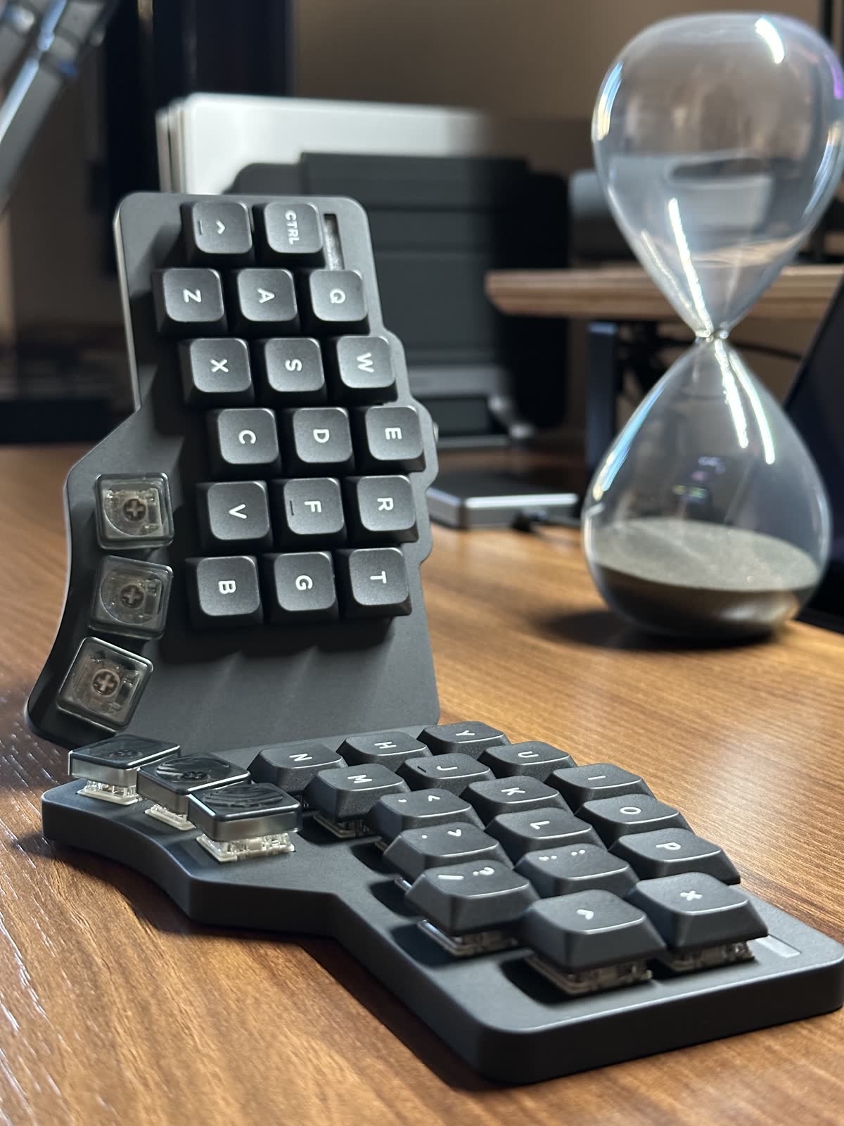 The finished keyboard on a desk beside an hourglass