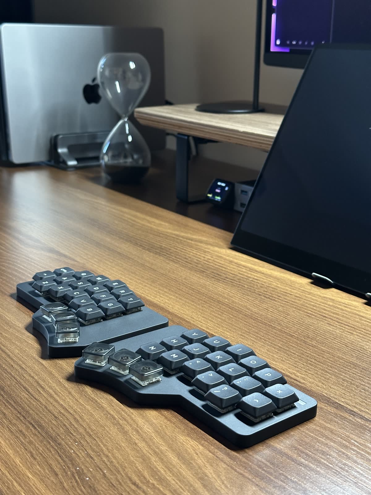 The two keyboard halves photographed at an angle on a wooden desk